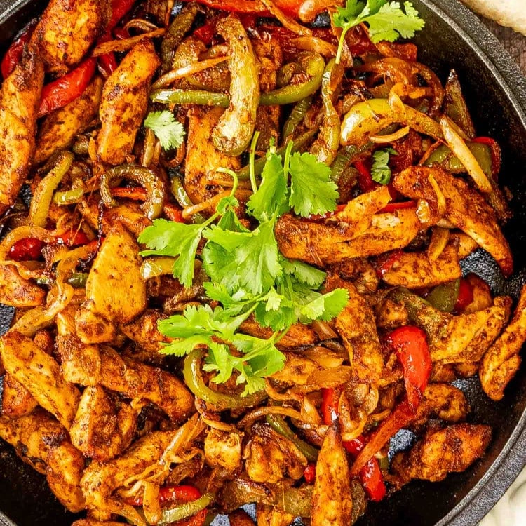 chicken fajitas that were made in an air fryer in a black skillet.