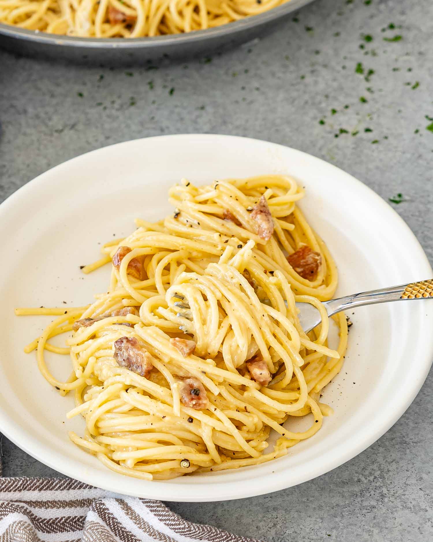a serving of freshly made carbonara in a white plate.