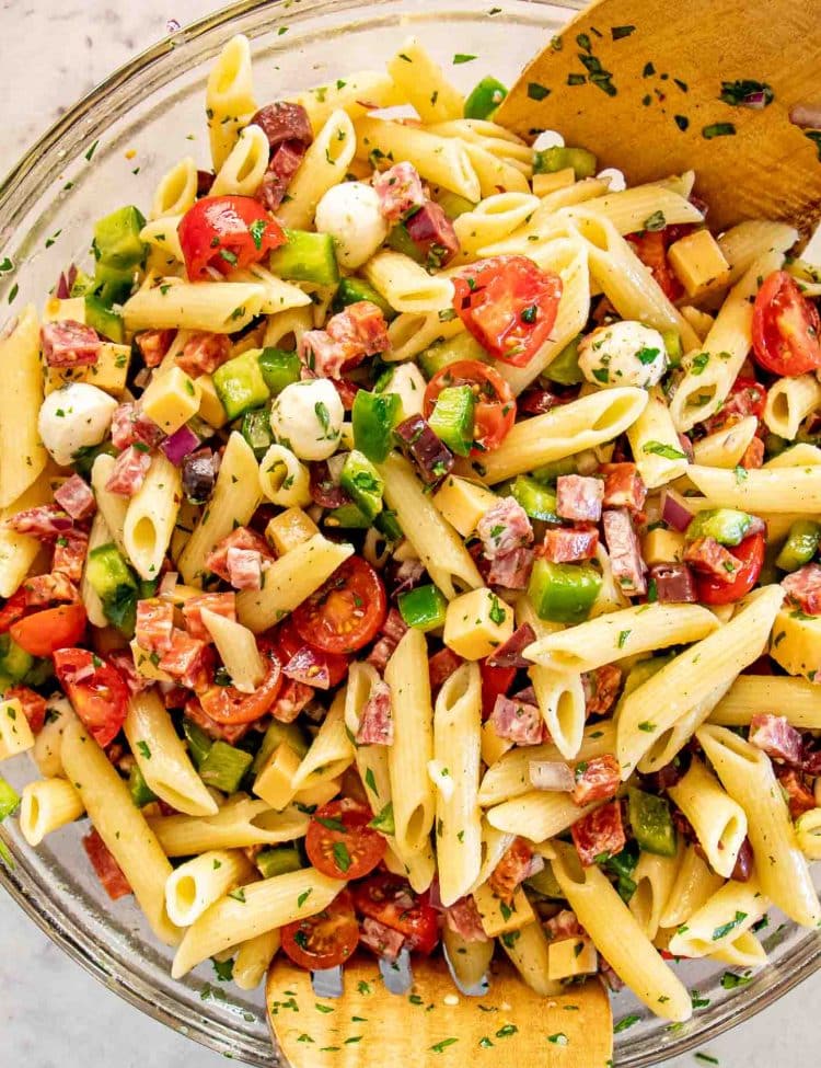 freshly made and tossed italian pasta salad in a bowl.