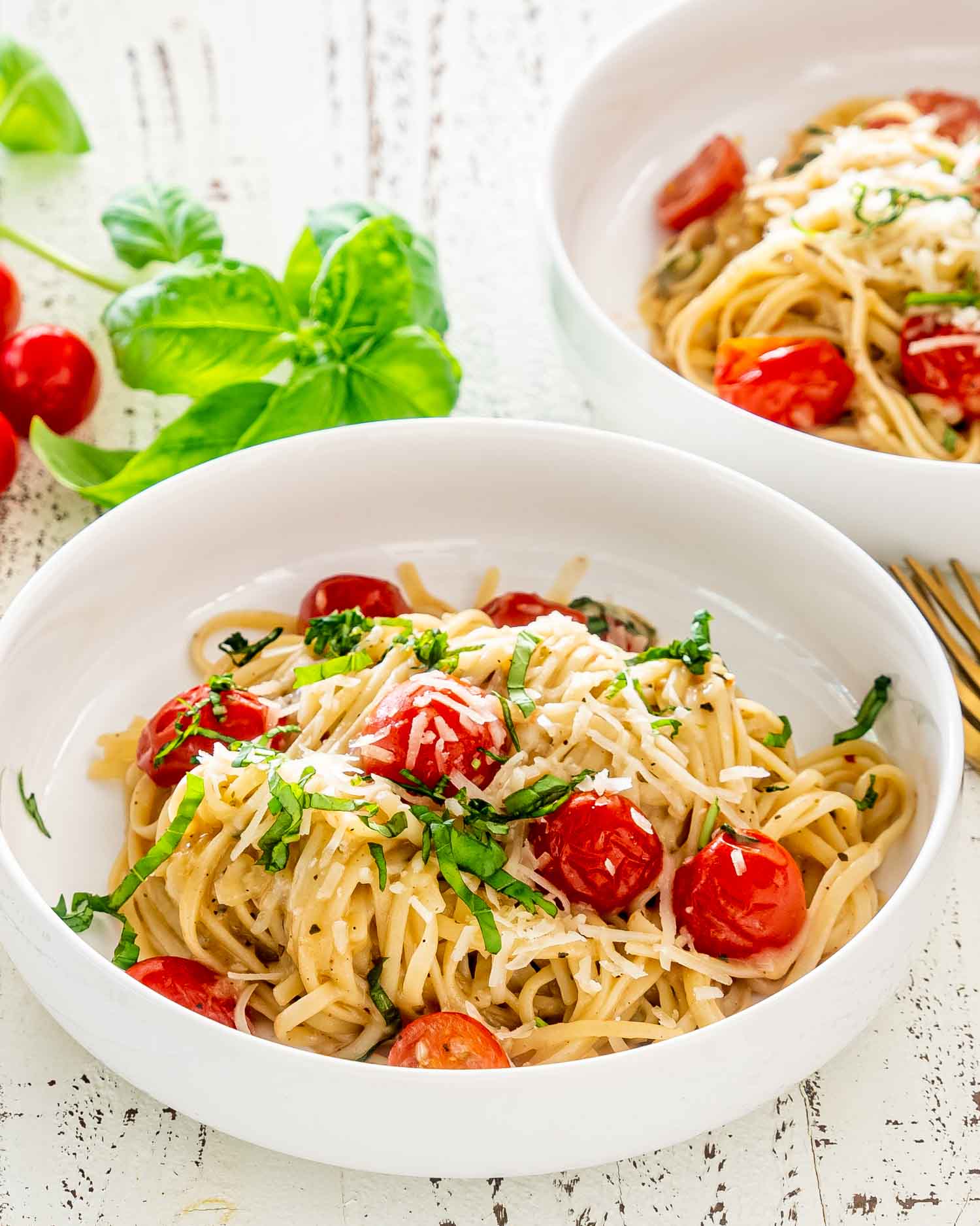 freshly made one pot pasta in white bowls garnished with basil.