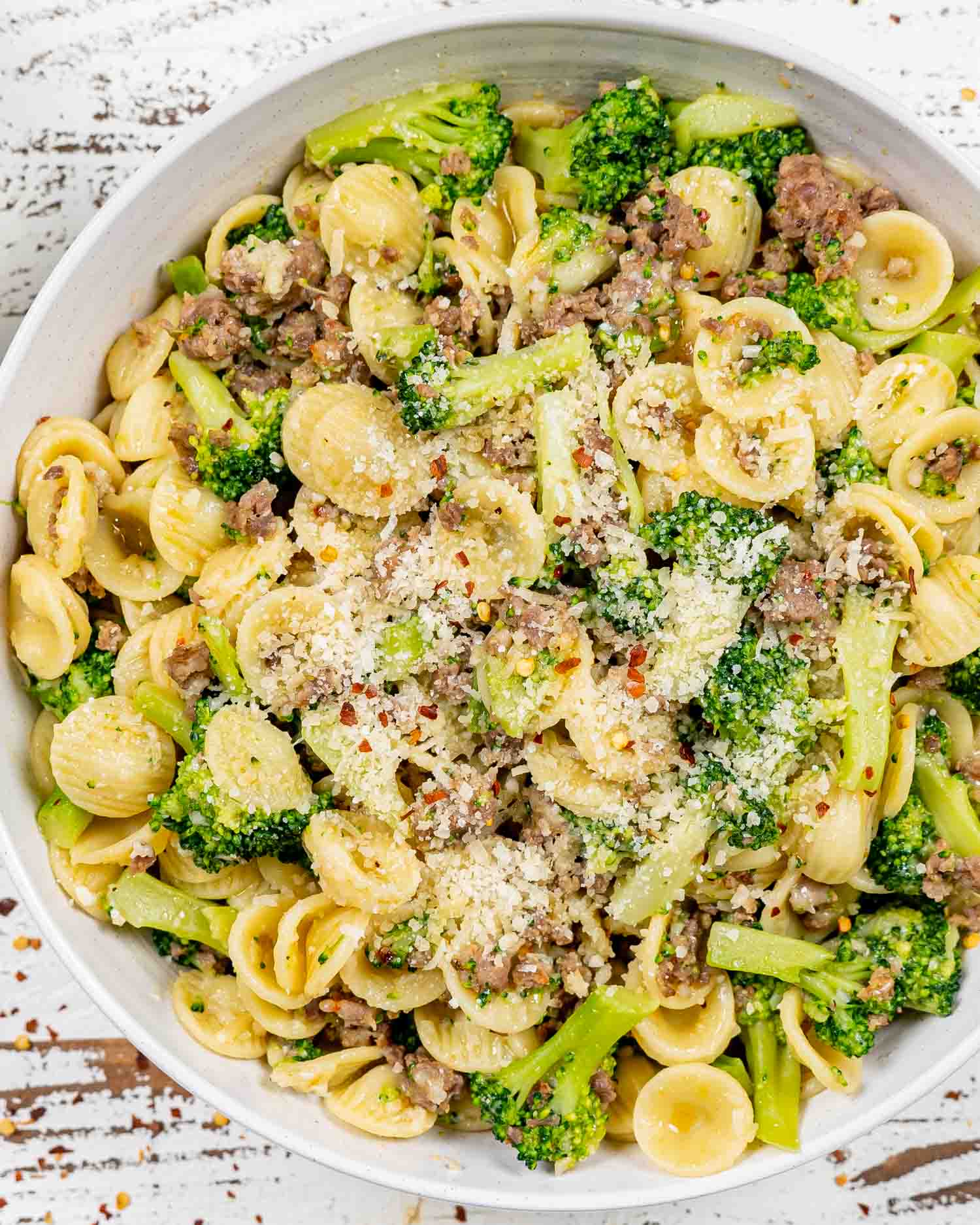 orecchiette with sausage and broccoli in a white serving bowl.