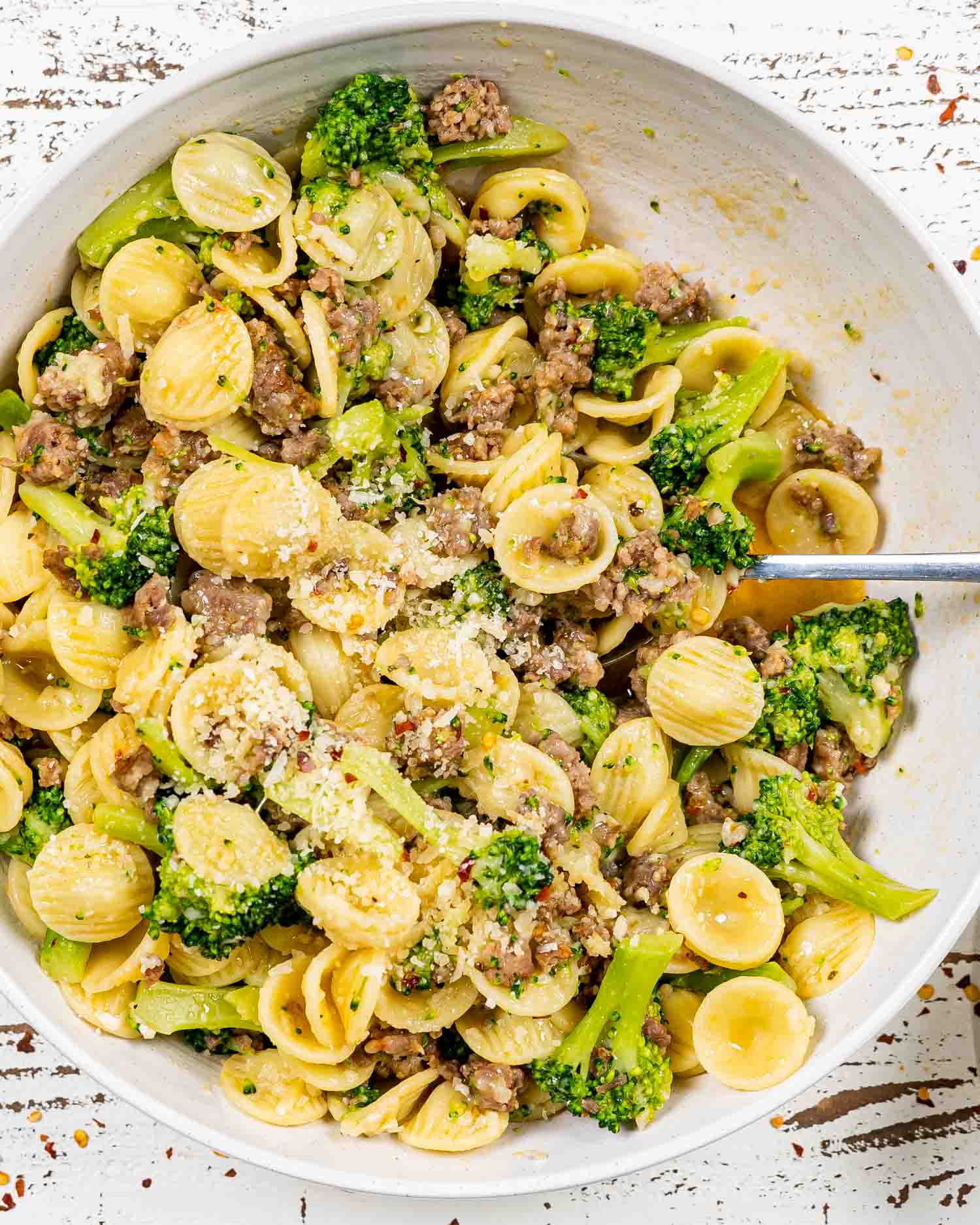 orecchiette with sausage and broccoli in a white serving bowl.