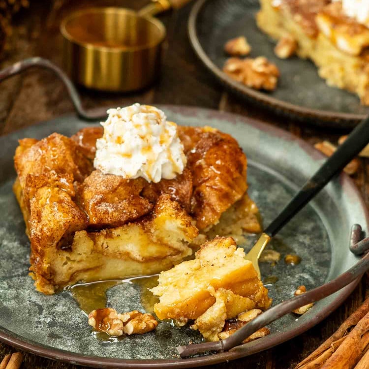 a slice of bread pudding with a dollop of whipped cream on a plate.