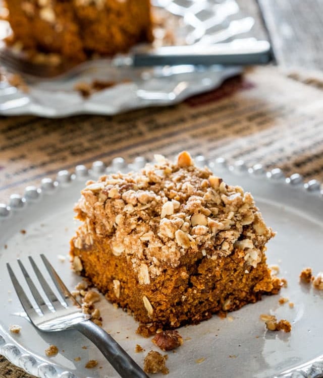 side view shot of a piece of pumpkin crumble cake on a plate with a fork