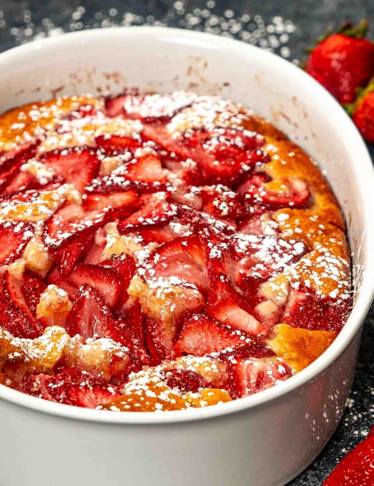 a freshly baked strawberry cobbler in a oval pan.