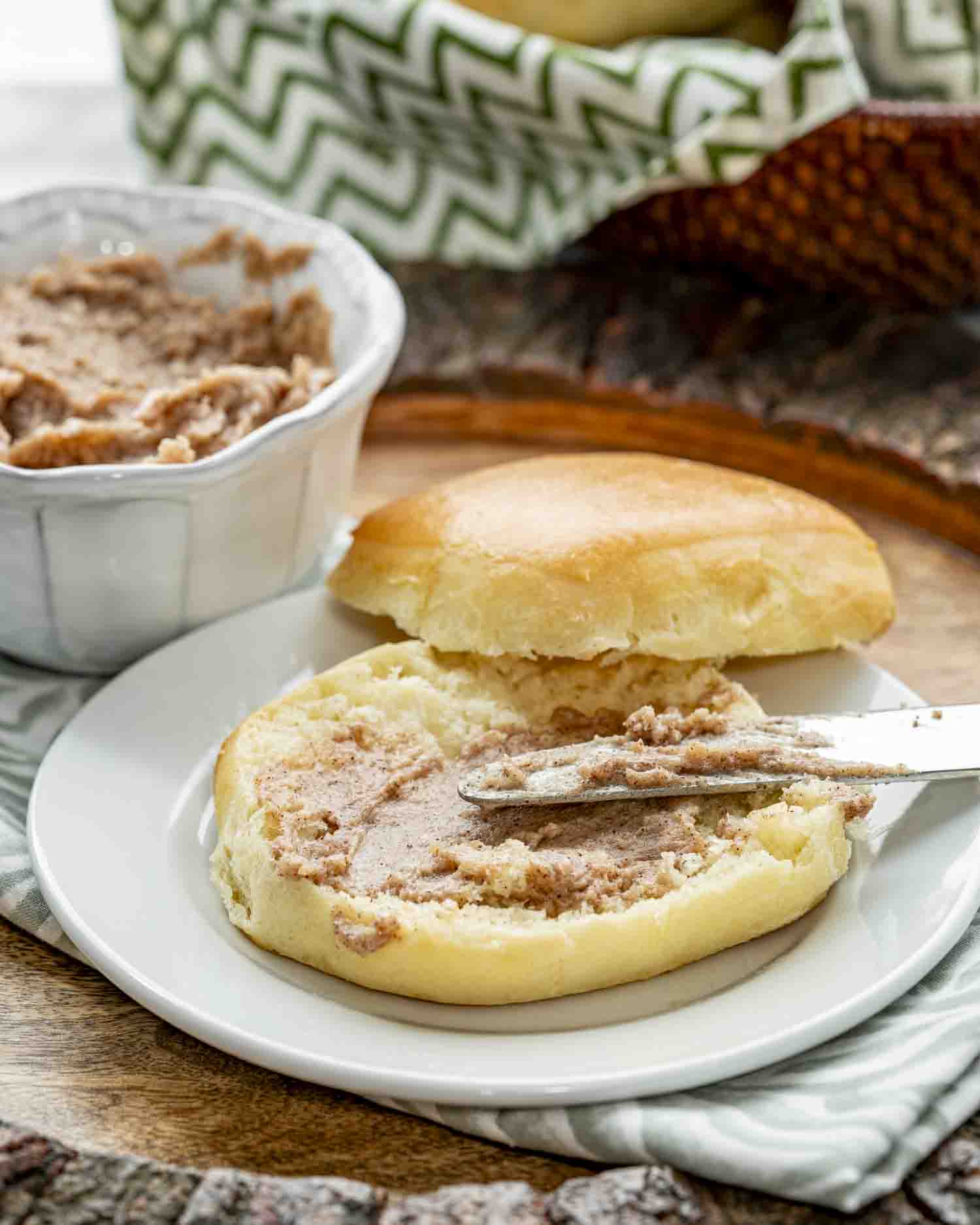 Texas Roadhouse Rolls a texas roadhouse roll with honey cinnamon butter on a white plate.